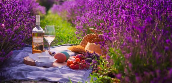 Oster Picknick mit Roséwein und Weinglas im blühenden Garten – Frühlingsstimmung mit Wein